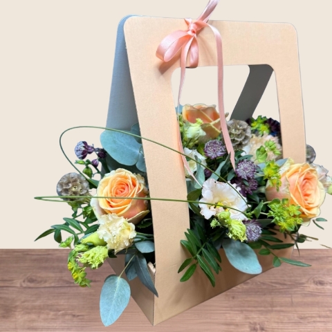 Birthday living flower card arrangement with peach roses, cream lisianthus and seasonal flowers presented in a card-style floral gift.