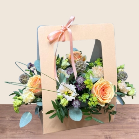 Birthday living flower card arrangement with peach roses, cream lisianthus and seasonal flowers presented in a card-style floral gift.