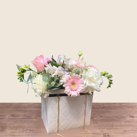 Mother’s Day flower arrangement in a white handbag gift container with soft pastel blooms, Paris collection West Malling florist