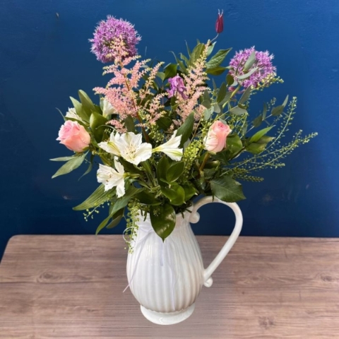 Pastel seasonal flower arrangement in white ceramic jug