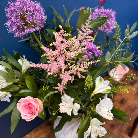 Pastel seasonal flower arrangement in white ceramic jug