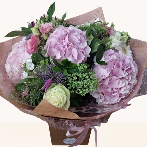 Luxury bouquet of pink hydrangeas with seasonal white and lilac flowers in a soft pastel colour palette.