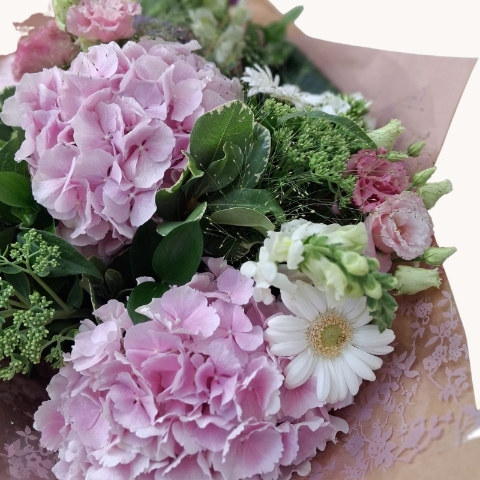 Luxury bouquet of pink hydrangeas with seasonal white and lilac flowers in a soft pastel colour palette.