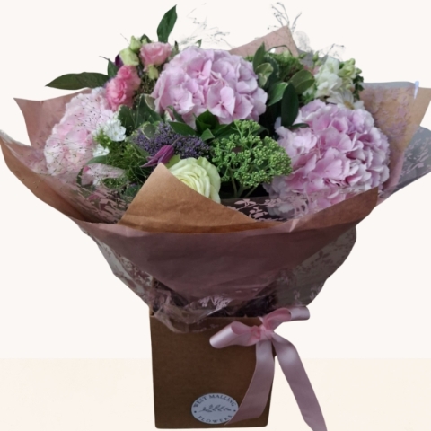 Luxury bouquet of pink hydrangeas with seasonal white and lilac flowers in a soft pastel colour palette.