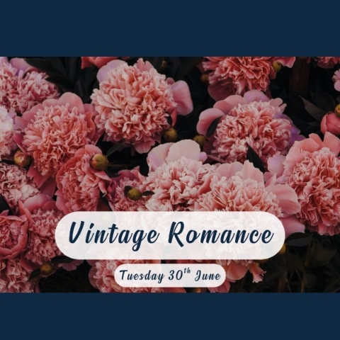 Vintage style flower arrangement with candle and pink burgundy seasonal flowers