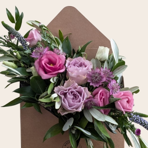 Pastel summer flower arrangement in kraft envelope with pink and lilac seasonal flowers