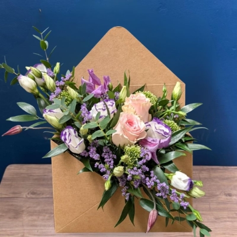Pastel summer flower arrangement in kraft envelope with pink and lilac seasonal flowers