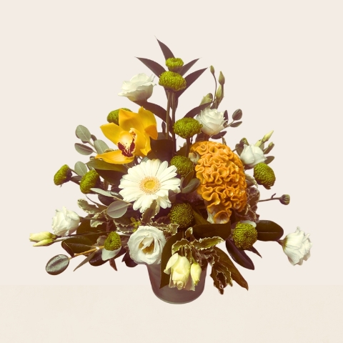 Summer flower arrangement in a zinc pot featuring fresh yellow, lemon and white seasonal flowers with mixed foliage.