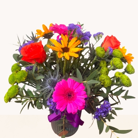 Summer Splash blue glass vase arrangement with vibrant pink, orange, purple and green seasonal flowers