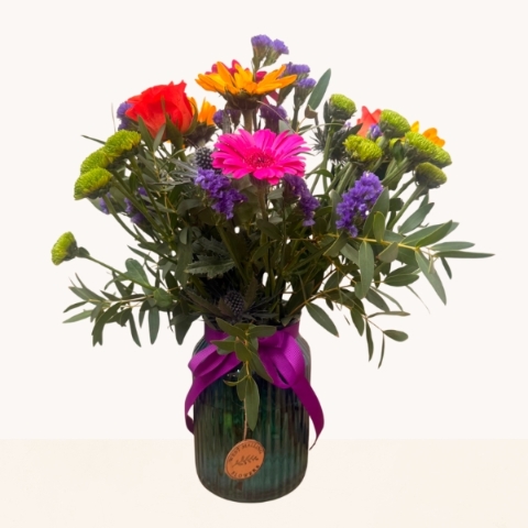 Summer Splash blue glass vase arrangement with vibrant pink, orange, purple and green seasonal flowers