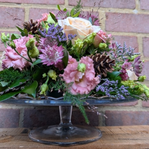 Autumn Blush flower arrangement on a glass cake plate with pink, champagne and lilac seasonal flowers