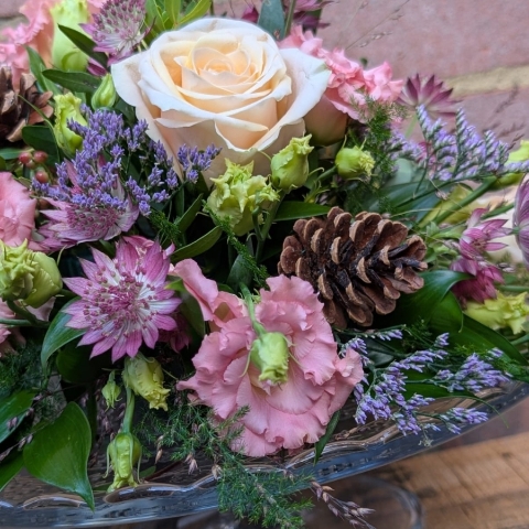 Autumn Blush flower arrangement on a glass cake plate with pink, champagne and lilac seasonal flowers
